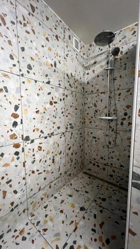 a bathroom with a shower with a tiled wall at It Wûnder in Oude Bildtzijl