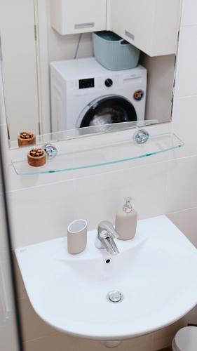 a bathroom with a sink and a washing machine at Apartment SOFI Belville in Novi Beograd