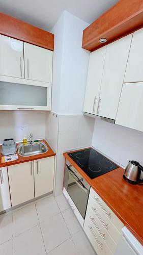 a small kitchen with white cabinets and a sink at Apartment SOFI Belville in Novi Beograd