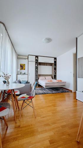 a living room with a bed and a table and chairs at Apartment SOFI Belville in Novi Beograd