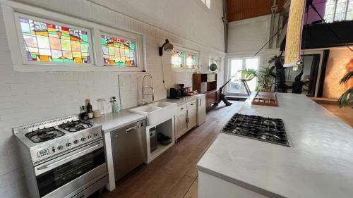 a kitchen with white appliances and stained glass windows at It Wûnder in Oude Bildtzijl