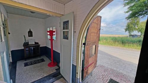 an entrance to a house with a door and a red pole at It Wûnder in Oude Bildtzijl