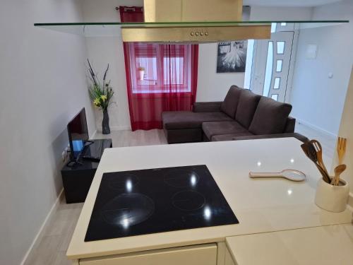 a kitchen and living room with a stove and a couch at Cantinho Acolhedor in Arrabal