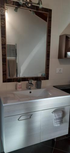 a bathroom sink with a large mirror above it at La Tór Appartamenti - Pramotton in Donnas
