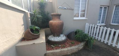 a vase sitting outside of a house with potted plants at 21 A on Edgerton in Freeland Park