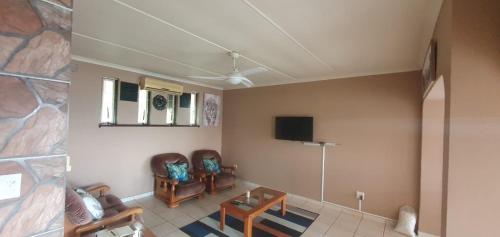 a living room with two chairs and a table and a tv at 21 A on Edgerton in Freeland Park