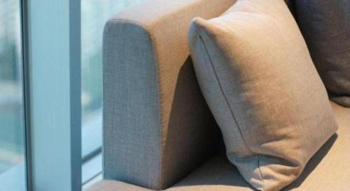 a couch with a pillow sitting next to a window at Empark Grand Hotel Fuzhou in Fuzhou