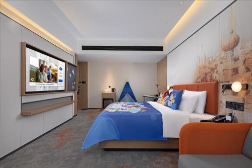 a bedroom with a bed and a flat screen tv at Hampton By Hilton Dongguan Nancheng Xiping in Baima