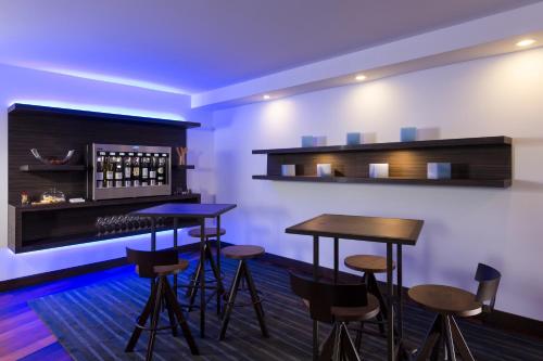 a bar with stools and tables in a room at Hôtel Le Bonne Entente in Quebec City