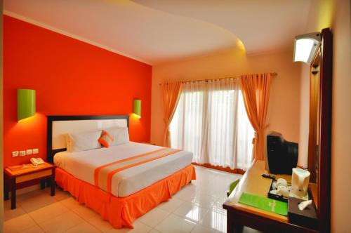 a hotel room with a bed and a television at Grand Sinar Indah in Legian