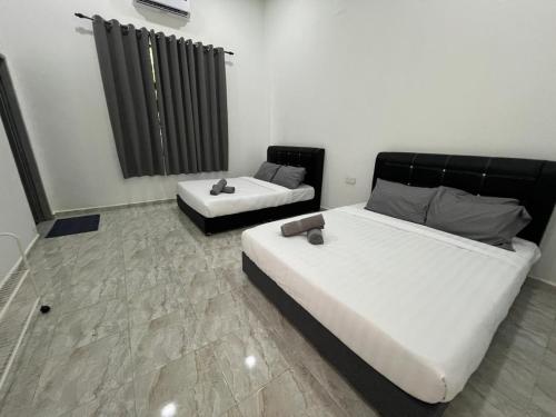 a bedroom with two beds and a radiator at CasaView Island Marang in Marang