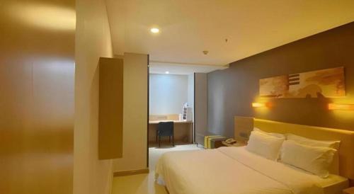 a hotel room with a bed and a desk in it at 7 Days Premium Xi'an Dayan Tower Xiaozhai Metro Station in Xi'an