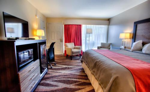 a hotel room with a bed and a flat screen tv at The Beaucatcher, a Boutique Motel in Asheville