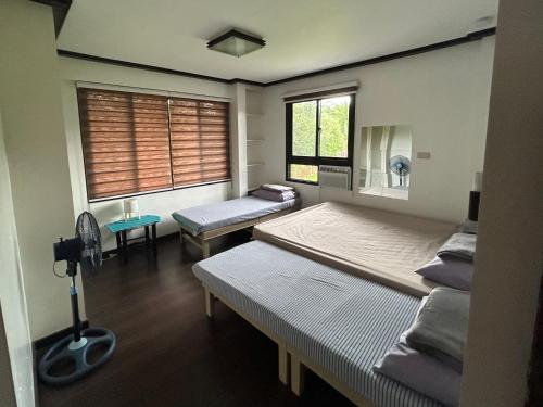 a room with two beds and a window at MG Holiday Home Tagaytay in Tagaytay