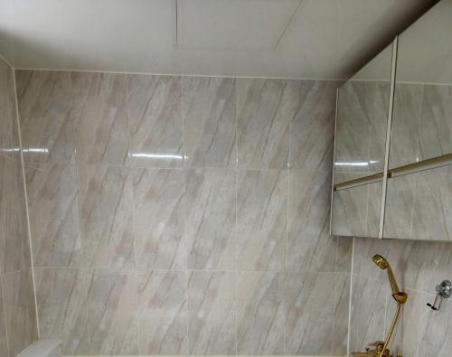 a bathroom with a shower with marble tiles at THE OCEAN Pension in Sokcho