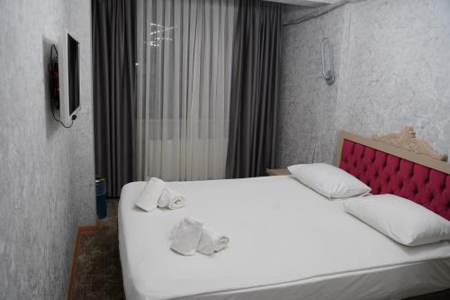 a bedroom with a large white bed with a red headboard at Turk Art Hotel in Istanbul