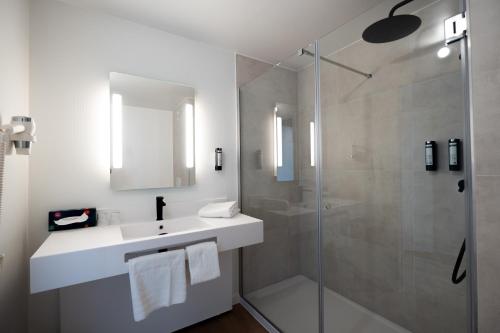 un bagno con lavandino e doccia in vetro di B&B HOTEL Mons Gare a Mons