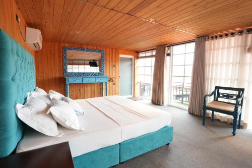 a bedroom with a large bed and a chair at Elephyard Retreat in Mahiyangana