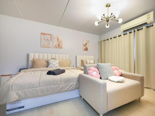 a bedroom with a large bed and a couch at Cozy 2BR Near Impact Arena, LTAT- WiFi Washer near DMK at C2 in Ban Song Hong