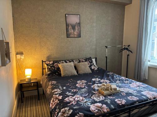 a bedroom with a bed with a blue comforter and flowers at Affordable Golden Mile Hotel In Blackpool Close To The Beach And Blackpool City Centre With Free Street Parking Subject To Availabilty in Blackpool