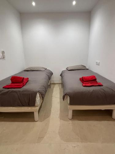 - 2 lits dans une chambre avec des serviettes rouges dans l'établissement STA4 Le Suquet, Proche Mer et Palais des Congrès, à Cannes