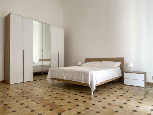 ein weißes Schlafzimmer mit einem Bett und einem Spiegel in der Unterkunft Dimora Immacolata in Castellana Grotte