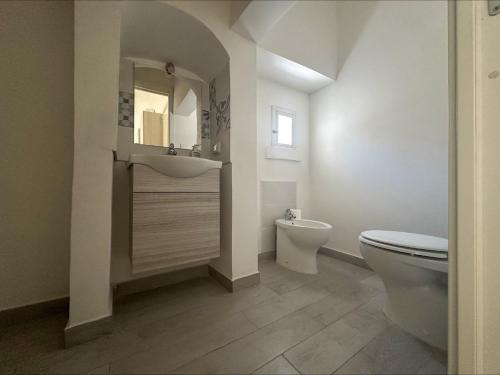 ein Badezimmer mit Toilette, Waschbecken und Spiegel in der Unterkunft Dimora Immacolata in Castellana Grotte