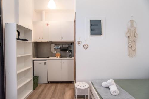 a small kitchen with white cabinets and a table at Olesia Rooms in Naousa in Naousa