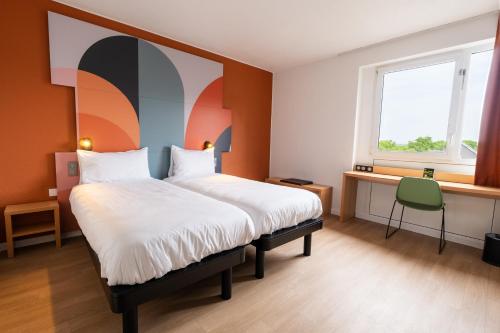 a bedroom with a large bed with a large painting on the wall at B&B HOTEL Mons Gare in Mons
