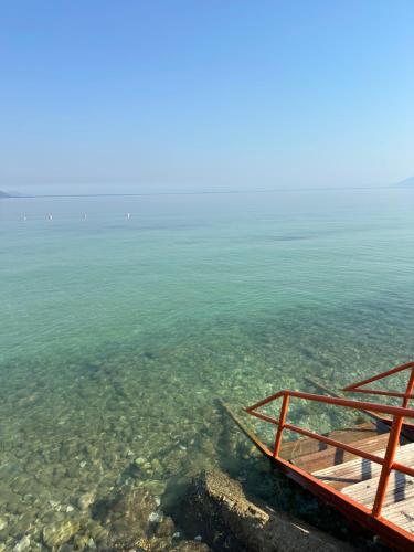 a boat in the water next to the ocean at Sunrise Hotel Orikum in Orikum