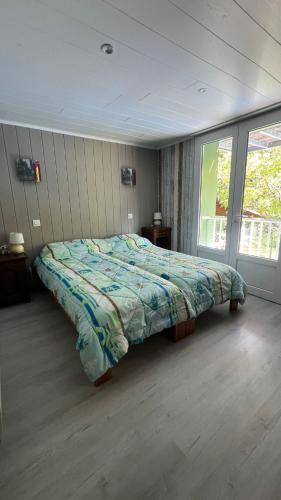 une chambre avec un lit avec une couette dessus dans l'établissement Maison au bord de l'eau avec Jacuzzi, à Millau