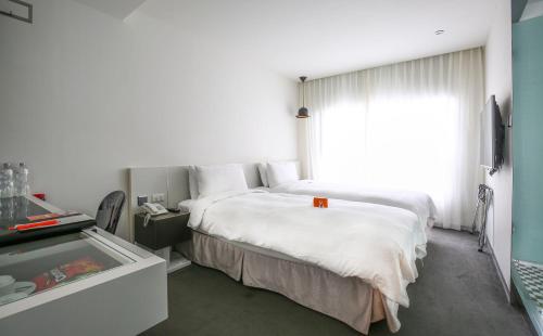 a hotel room with a bed and a window at CityInn Hotel Taipei Station Branch III in Taipei