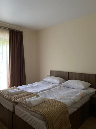 a bedroom with two beds with towels on them at Elnetsa Inn Kazbegi in Stepantsminda