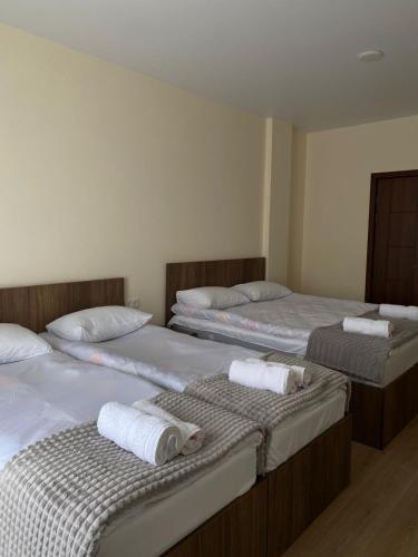 two beds in a room with towels on them at Elnetsa Inn Kazbegi in Stepantsminda