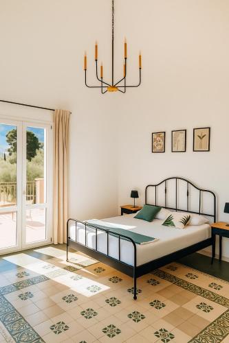 a bedroom with a bed and a chandelier at Villa Bona in Termini Imerese