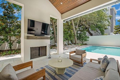 a living room with a fireplace and a swimming pool at Summer Nights in Santa Rosa Beach