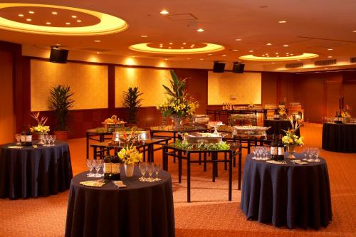 a banquet hall with tables and chairs with wine glasses at the b hachioji in Hachioji