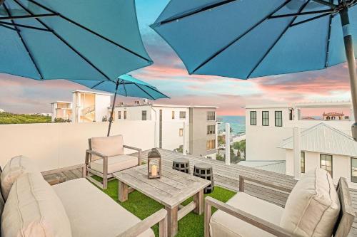 a patio with a table and chairs and an umbrella at Summer Nights in Santa Rosa Beach