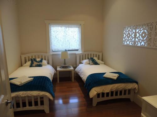 two beds in a small room with a window at Glenelg - Marina Retreat in Glenelg