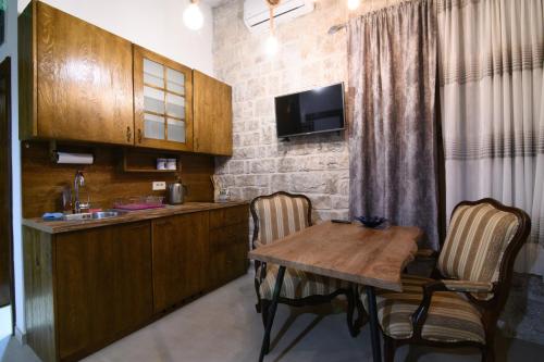 a kitchen with a wooden table and two chairs at Bed & Wine Djonovic in Virpazar