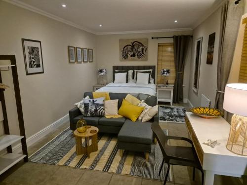 a bedroom with a bed and a couch and a living room at Striped Horse Guest House in Cape Town