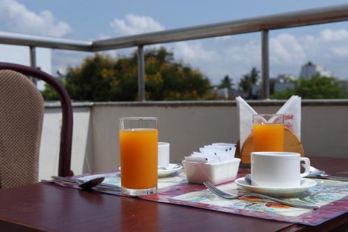 a table with two glasses of orange juice on it at Pondicherry Executive Inn in Puducherry