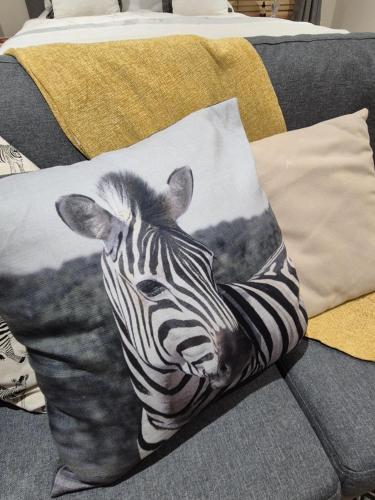 a black and white zebra pillow on a couch at Striped Horse Guest House in Cape Town