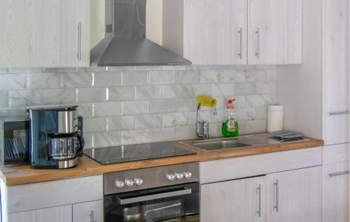 a kitchen counter with a sink and a stove at Nice Home In Norrtälje in Norrtälje