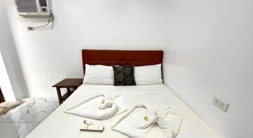 a bed with two white towels on top of it at Pilot Hotel in Alaminos