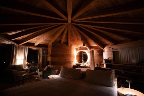 a bedroom with a large bed with a large ceiling at Au Charmant Petit Lac - Ecohotel Parc & Spa in Champoluc