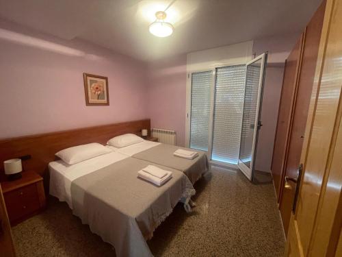 a bedroom with a bed with two towels on it at Apartamentos Villa de Ainsa in Aínsa