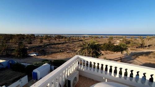 a balcony with a view of the beach at maison d hôte rêve de désert jerba in Al Ḩaddādah