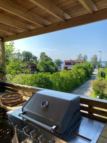a grill on a deck with a view of a street at Ljusterö Logi in Norra Ljustero