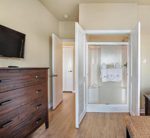 a bathroom with a walk in shower and a sliding glass door at Molokai Villas Riverside 7A in Perdido Key